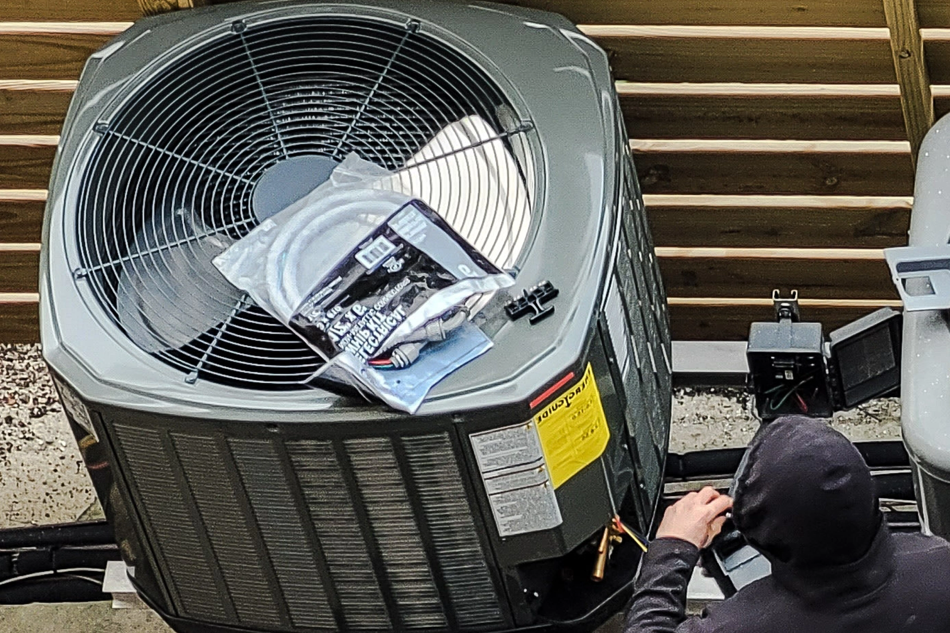 Technician servicing an air conditioning unit with maintenance tools nearby.