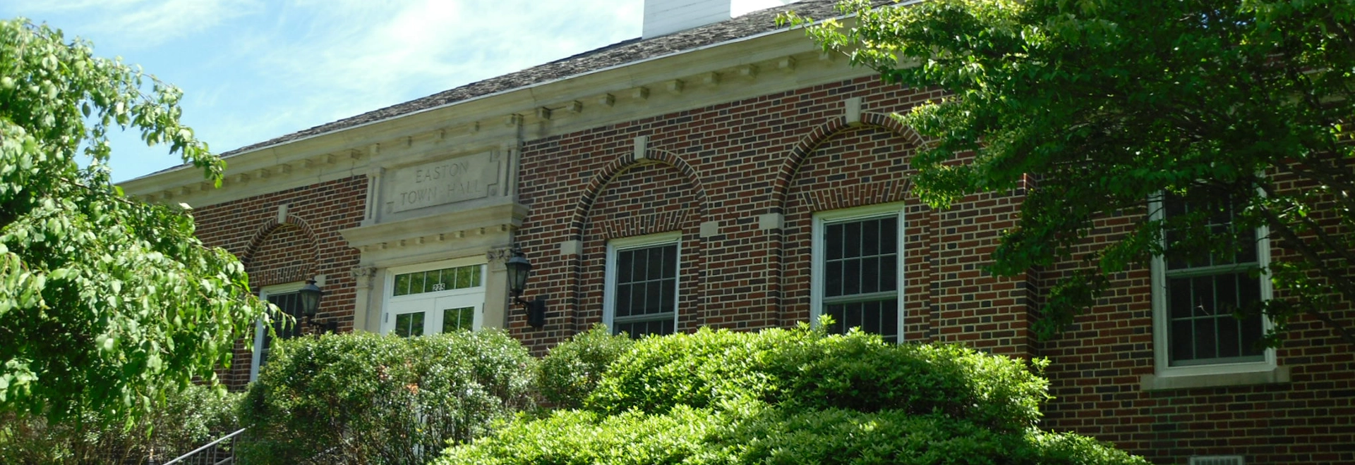 Easton Town Hall exterior with brick architecture and lush greenery.